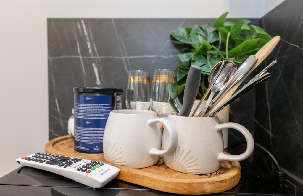 a table with two coffee cups and a remote control at Miniukas in Kaunas
