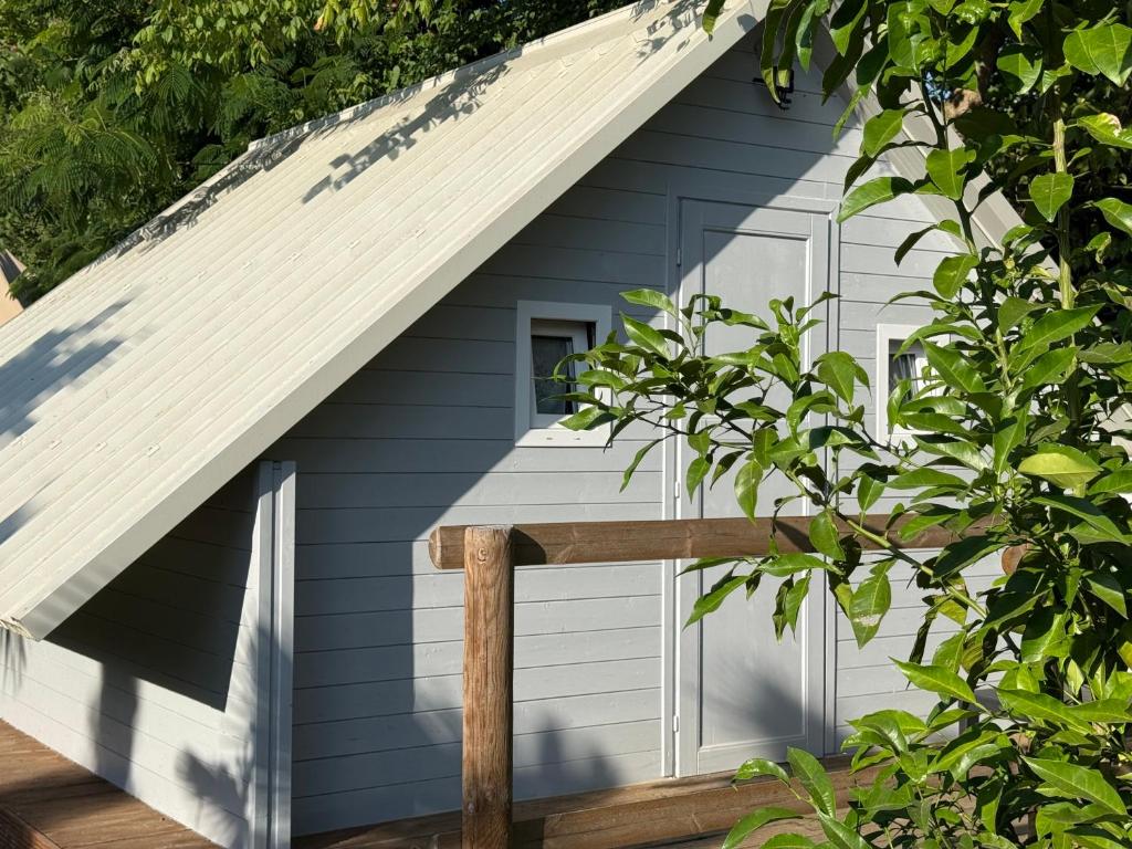 a house with a gambrel roof and a wooden porch at Il Pruno - Exclusive Tent in San Giuliano Terme