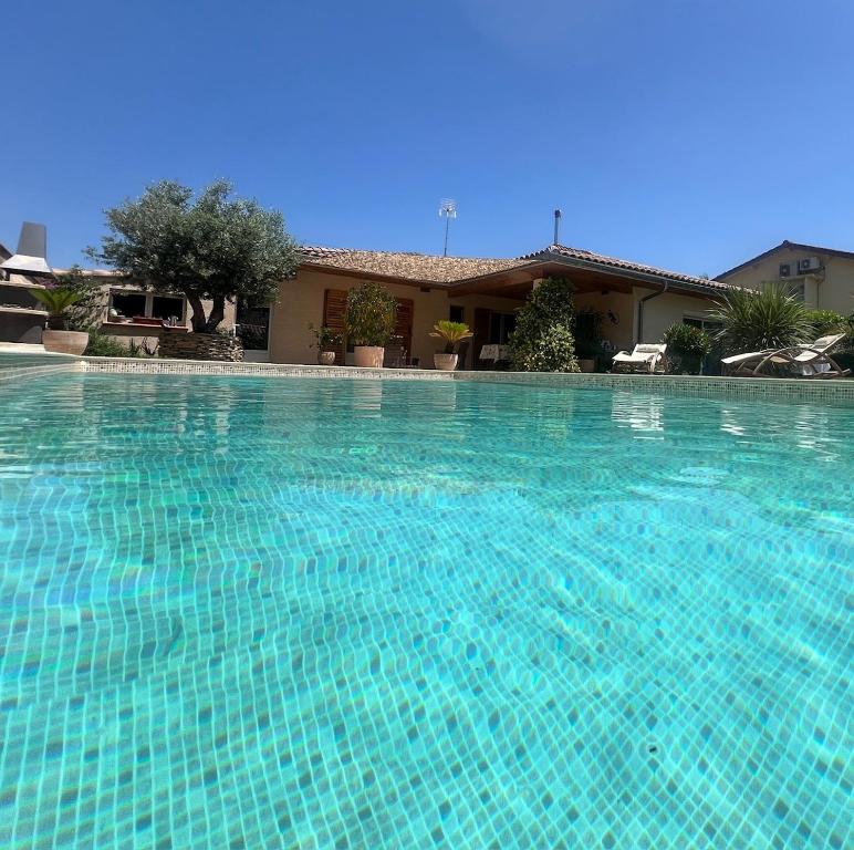 une grande piscine bleue devant une maison dans l'établissement Alba zen & spa, à Villefranche-de-Lauragais