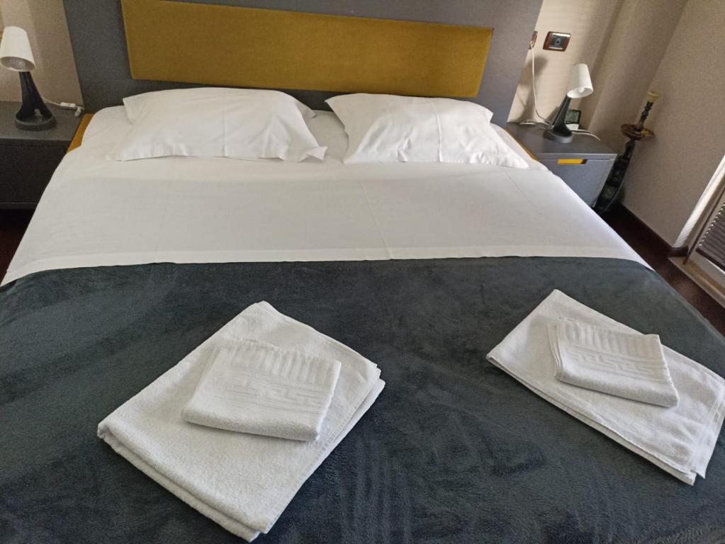 un letto con due asciugamani bianchi seduti sopra di The cozy flat a Tirana