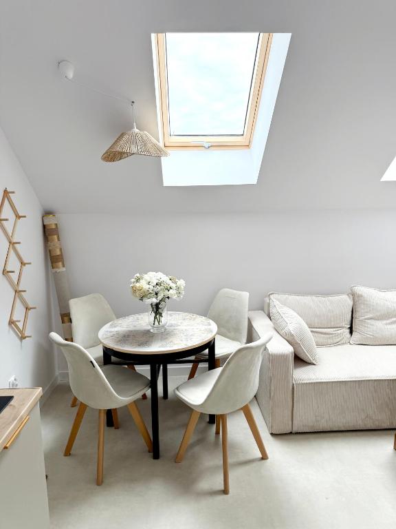 a living room with a table and chairs and a couch at Apartament Szyszka 2 in Rogowo