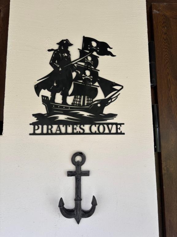 a sign with a pirate ship and an anchor at Pirate's Cove in Sukošan