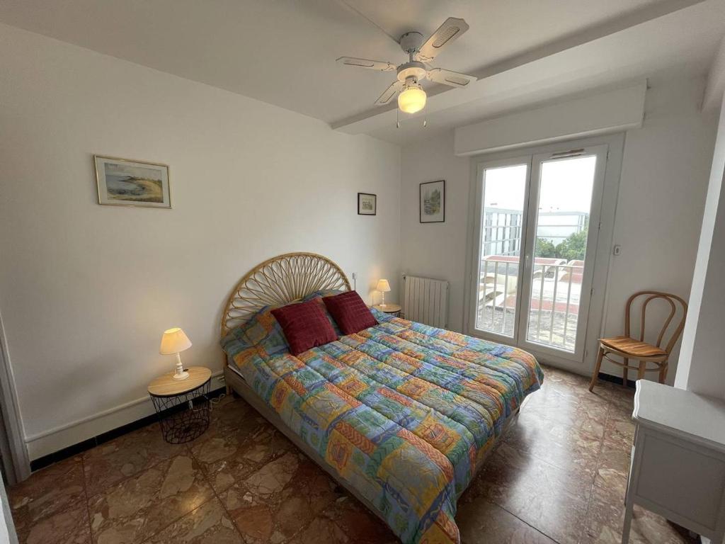 sypialnia z łóżkiem i wentylatorem sufitowym w obiekcie T2 cabine rénové, animaux admis, parking sécurisé, proche plage et port - Saint-Cyprien - FR-1-106-69 w mieście Saint-Cyprien