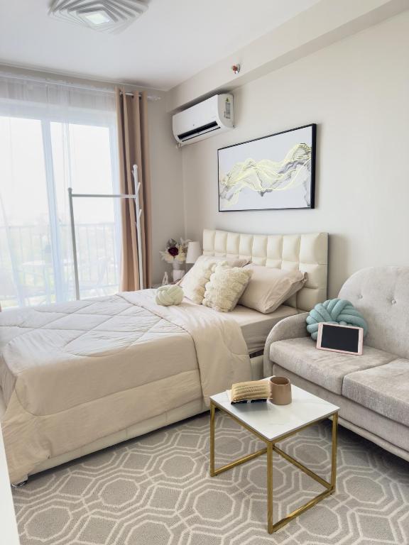 a living room with a large bed and a couch at The Cozy Clouds Staycation in Suba