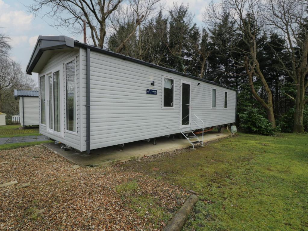 ルシンにあるWoodlands Gold WO06の庭の窓付き小さな白い小屋