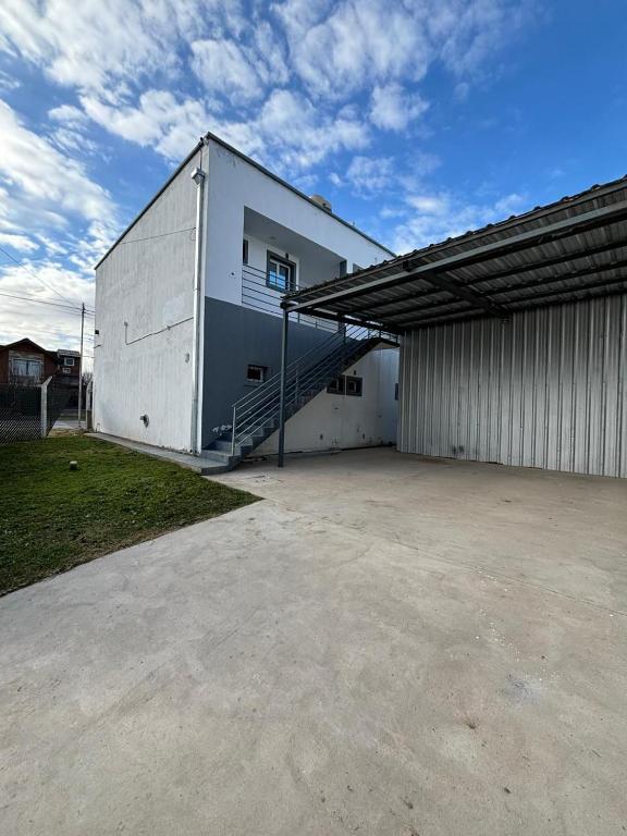 a large white building with a staircase in front of it at Amanecer Rio Limay in Plottier