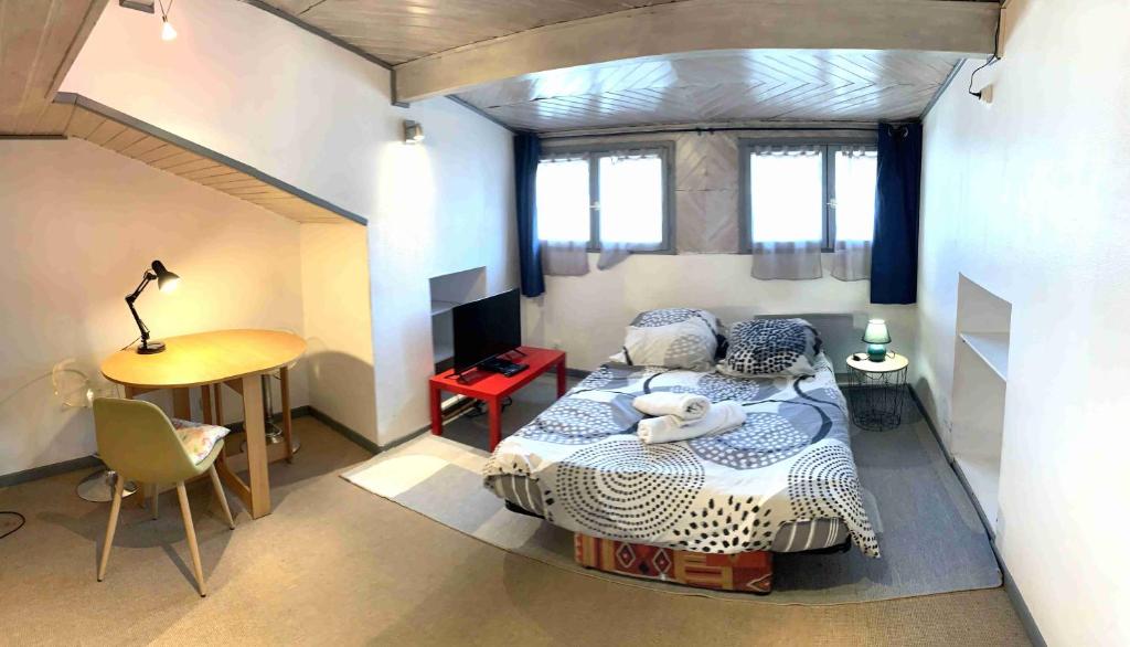 une petite chambre avec un lit et une table dans l'établissement Studio ITALY, à Chambéry