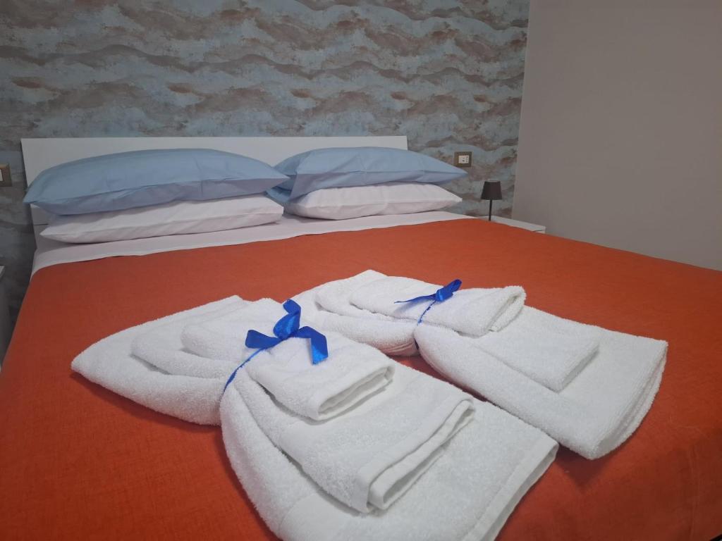 un letto con asciugamani e cuscini sopra di Machi House a Scafati