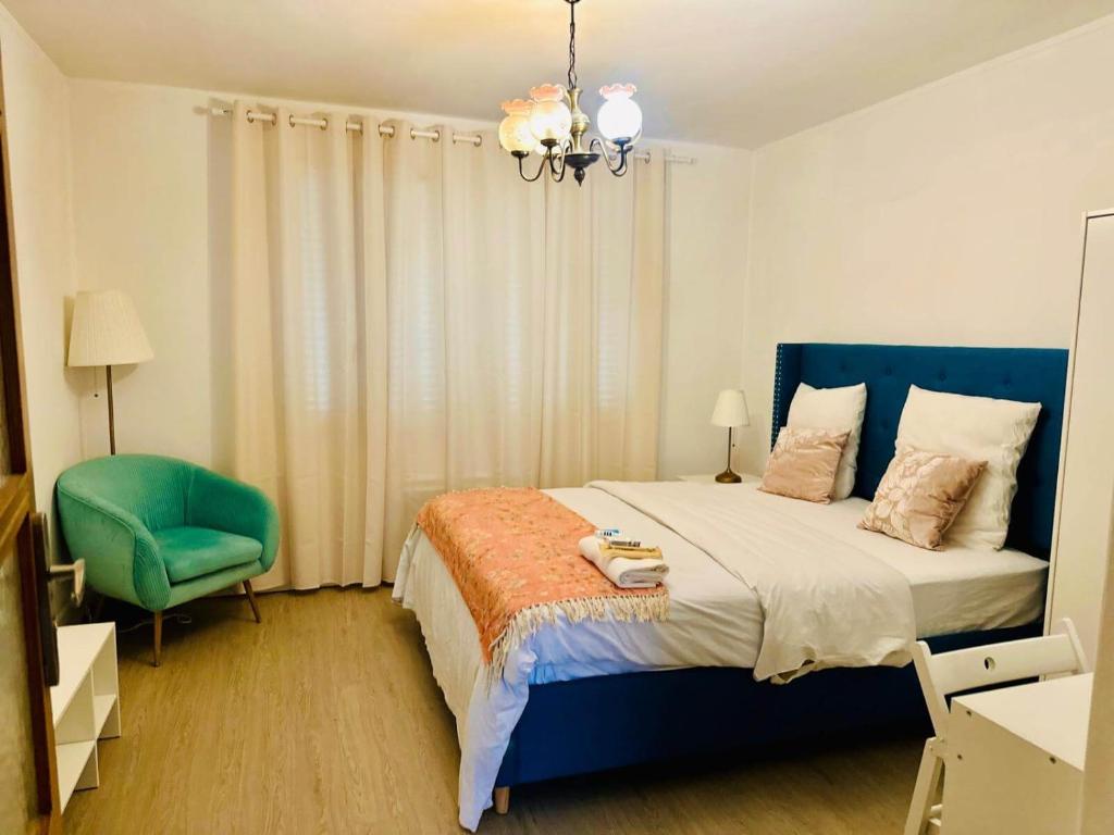 a bedroom with a blue bed and a green chair at Holiday Apartment 03 in Stains