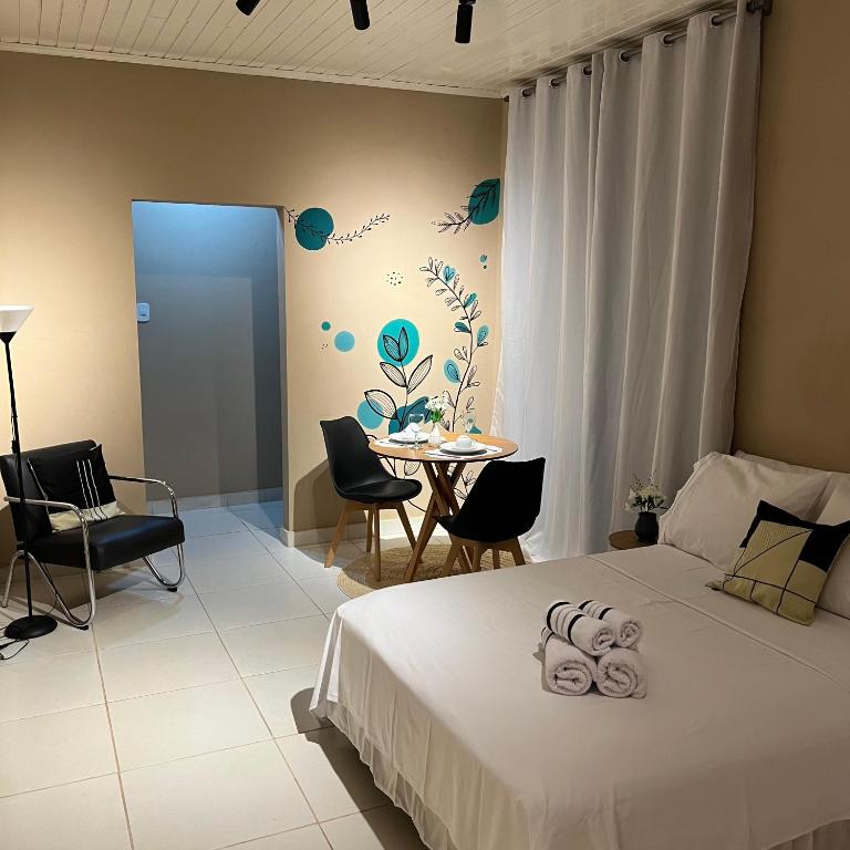 a bedroom with a bed and a table and chairs at Cantim d' Casa in Catas Altas