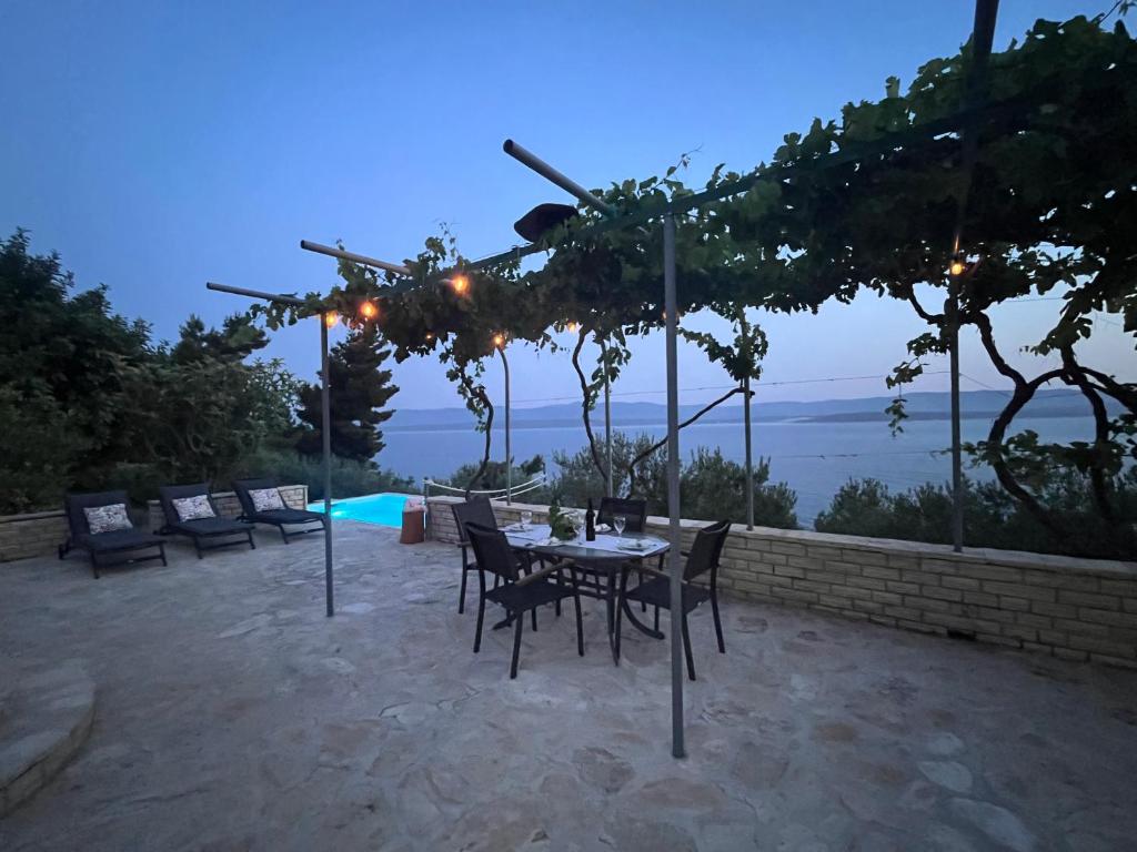 a patio with a table and chairs and a pool at Bol Cutie in Murvica