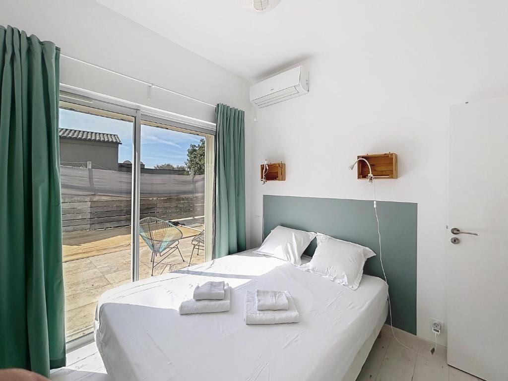 une chambre avec un lit et une grande fenêtre dans l'établissement Les Issambres, à Roquebrune-sur Argens