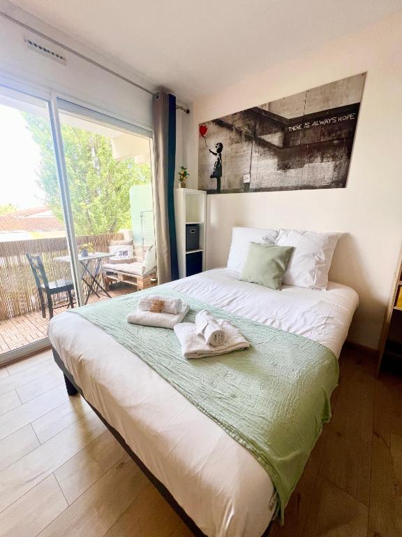 a bedroom with a large bed with towels on it at L'Estival, Royan in Royan