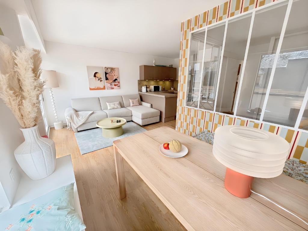 un salon avec un canapé et une table dans l'établissement Charmant Appartement au Cœur de Deauville avec Balcon et plage à 10 min à Pied, à Deauville