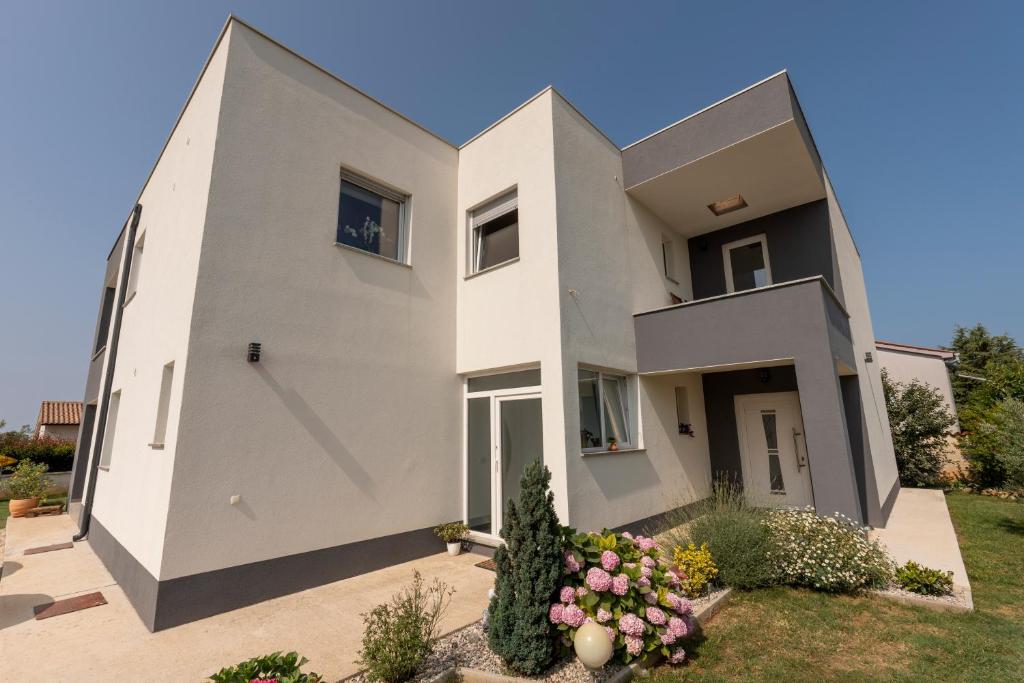 a large white house with a courtyard at Holiday home Galižana in Galižana