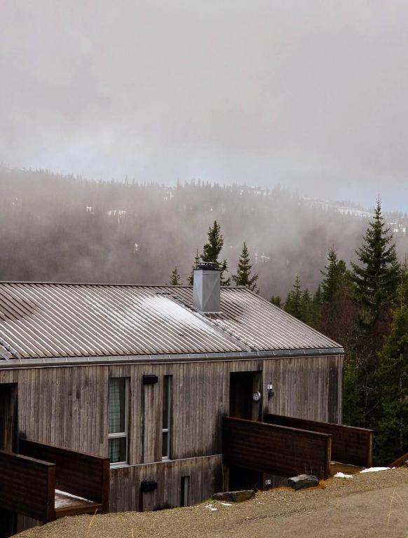a house with smoke coming out of it at Cozy Apartment by the slopes in Kvitfjell Vest in Favang
