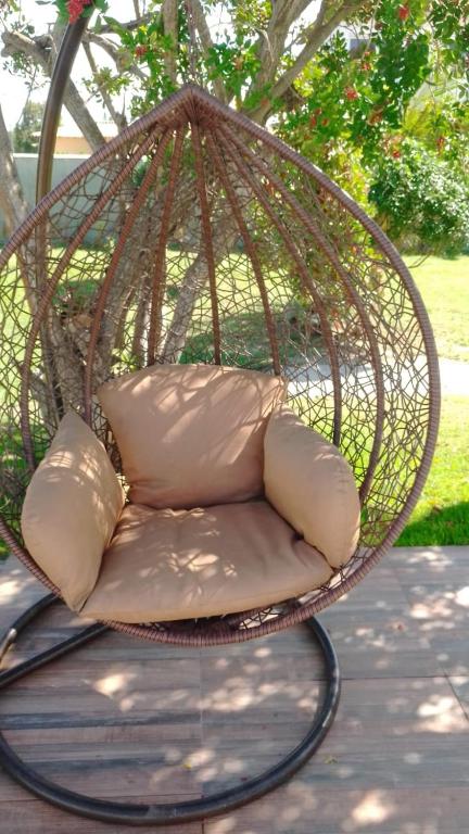 a swing chair with pillows sitting on a patio at Araruama junto a Lagoa - Centro in Araruama