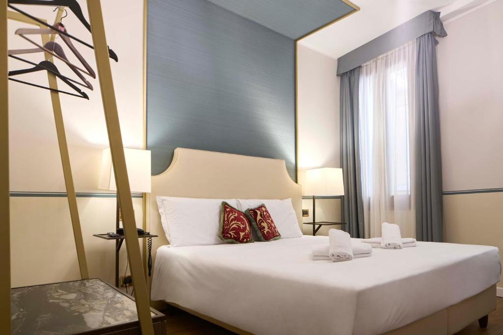 a bedroom with a large white bed and a window at Hotel Do Pozzi in Venice