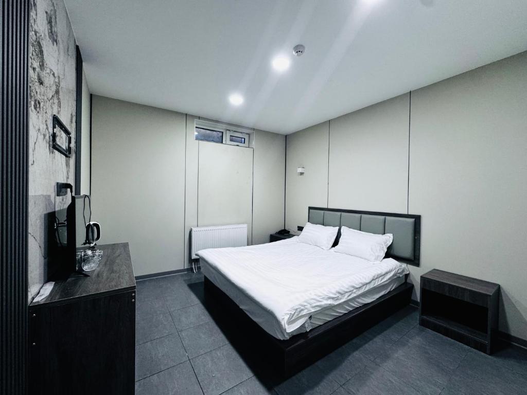 um quarto com uma grande cama branca e uma televisão em Lofty Hotel em Ulaanbaatar