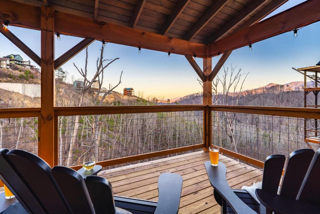 a screened in porch with chairs and a view of the mountains at Metal Manor in Gatlinburg