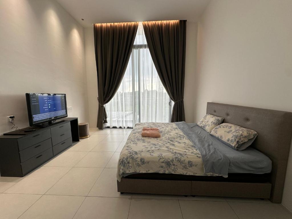 a bedroom with a bed and a flat screen tv at The Podium opp Aeon Mall Kuching in Kuching