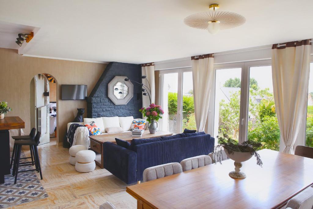 a living room with a blue couch and a table at Villa Saint-Martin in Jullouville-les-Pins
