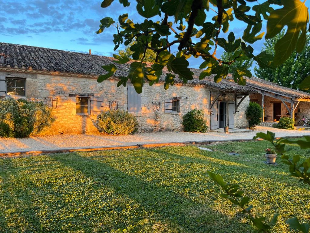 a stone house with a yard in front of it at Chambres d hôtes La Bourneloise in Bournel