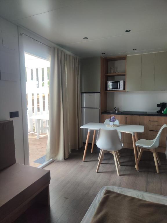 a kitchen with a table and a table and chairs at Camping Relax Sol in Torredembarra