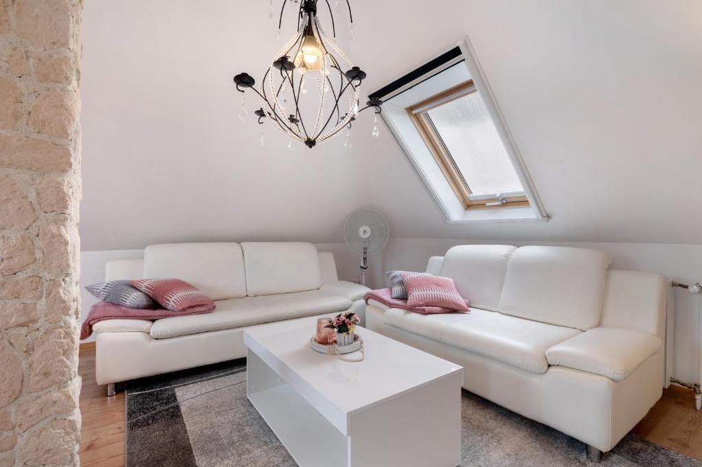 a living room with two white couches and a table at 3 Raum Ferienwohnung Im 1 Og in Cuxhaven