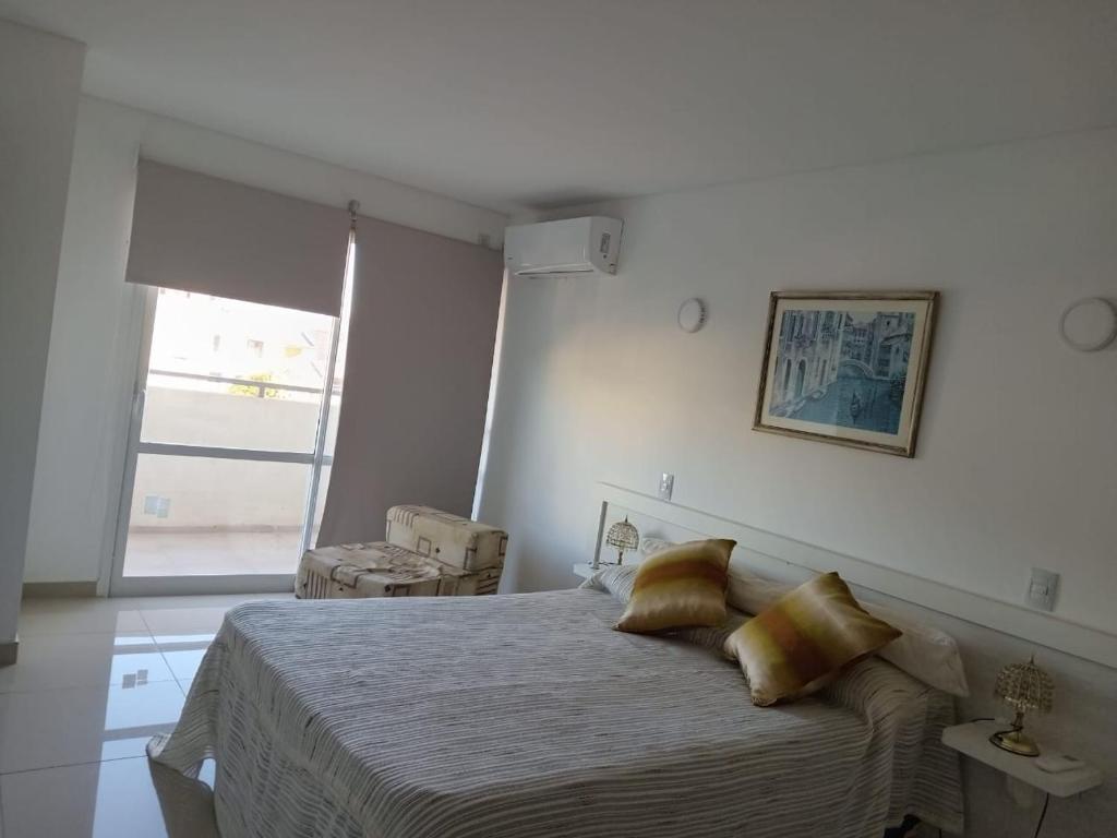 une chambre avec un grand lit et une fenêtre dans l'établissement Edificio Leonardo departamento 16, à Villa Carlos Paz