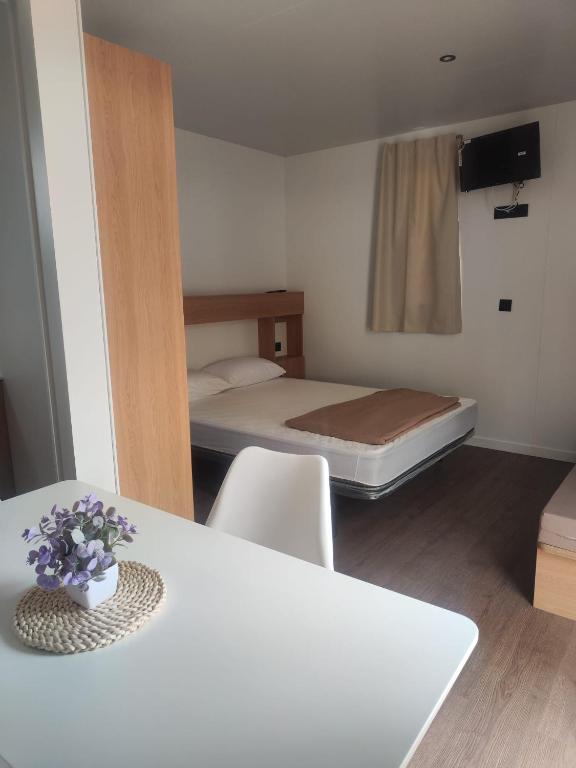 a small room with a bed and a table and chairs at Camping Relax Sol in Torredembarra