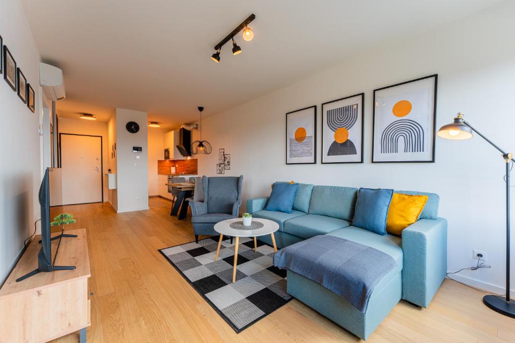 a living room with a blue couch and a table at Flex SelfCheckIns 142 - Zagreb - Bedroom - Garage - Loggia in Zagreb