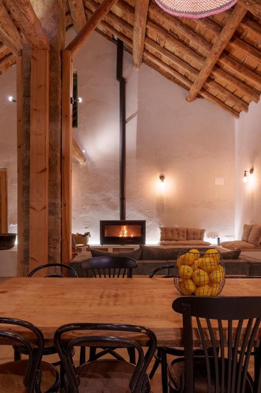 a dining room with a table and a fireplace at Borda Viñuels in Planillo