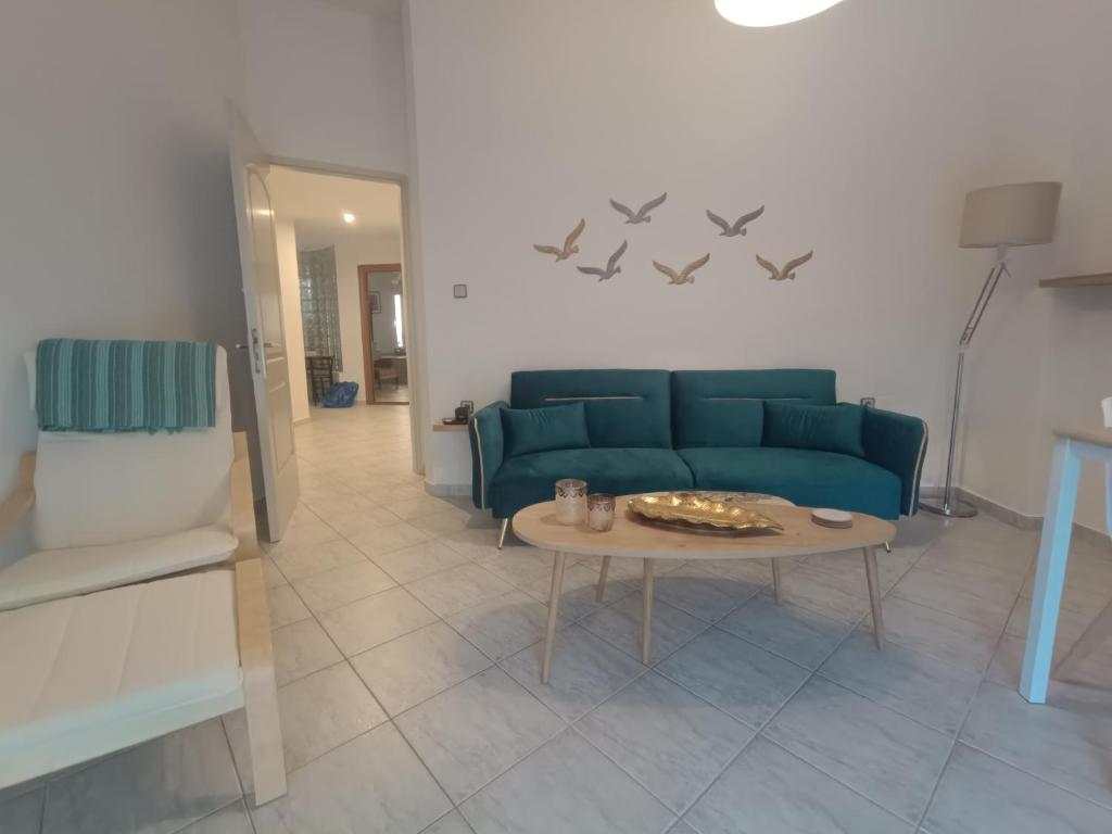 a living room with a blue couch and a table at Salamina Azuro in Selínia