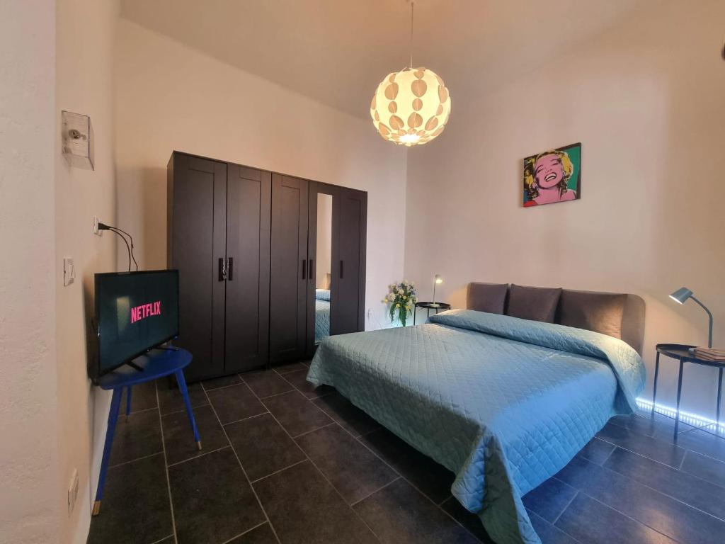 a bedroom with a bed and a flat screen tv at Victoria's Urban Nest in Brescia