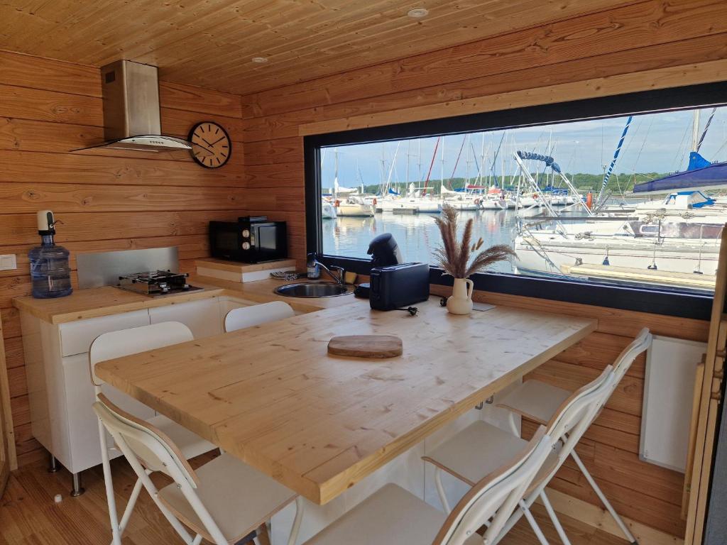 a kitchen with a wooden table and a large window at Bateau panoramique sans permis Lac du Der - Eclaron in Sainte-Livière