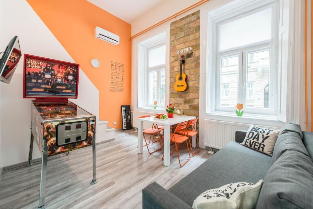 un soggiorno con divano e tavolo di happy home POP - apartment with free Pinball Machine a Budapest