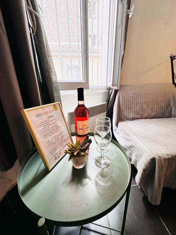 une bouteille de vin et un verre sur une table dans l'établissement Jojo appartement 1 chambres Paris-La défense, à Puteaux