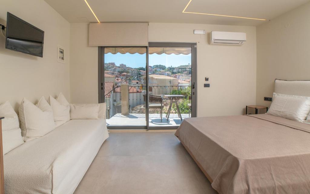 a bedroom with two beds and a large window at Baywatch LUXURY BOUTIQUE in Parga