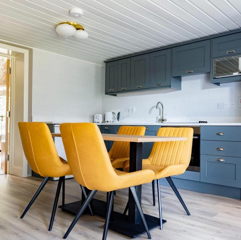 a kitchen with a table and yellow chairs at Newly Refurbished Self-Catering Lodge Sleeping 3 in Wexford