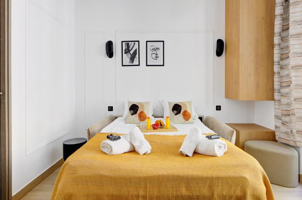 une chambre avec un lit avec des serviettes dessus dans l'établissement Bluestay 288 - Superbe studio à Paris 17, à Paris