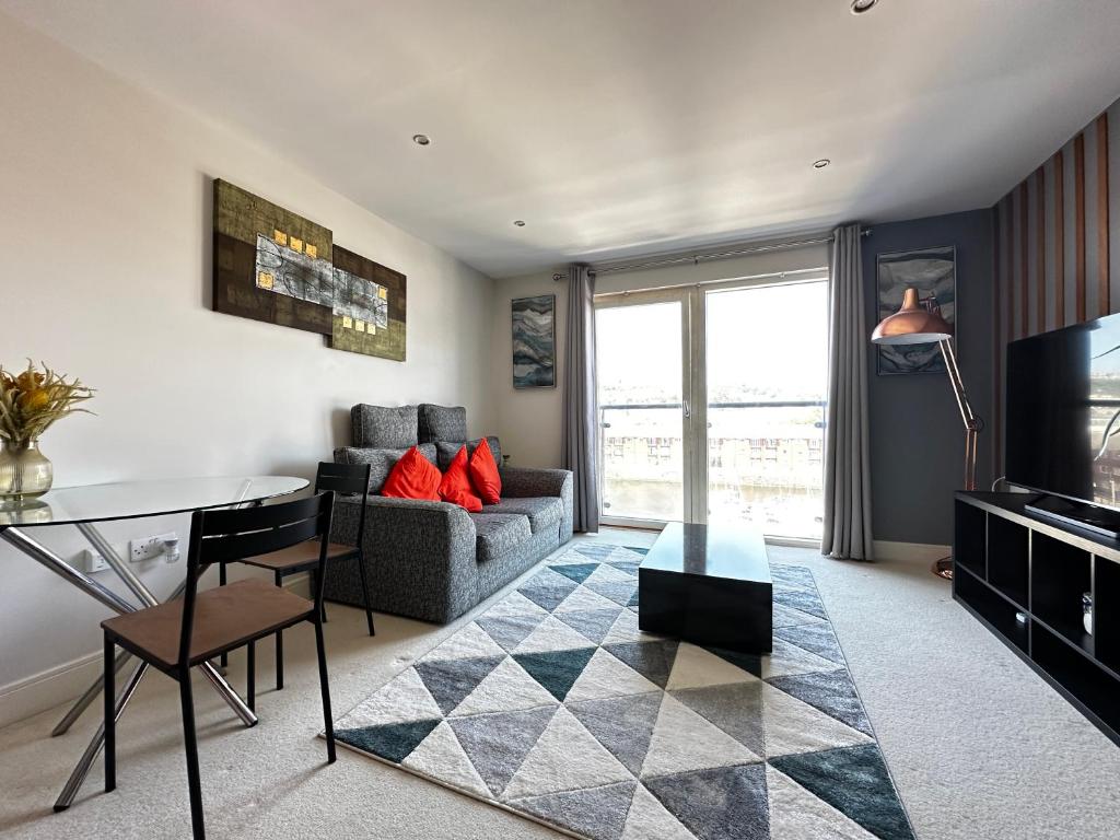un soggiorno con un divano e un tavolo di Seaside APT with Harbour View a Swansea