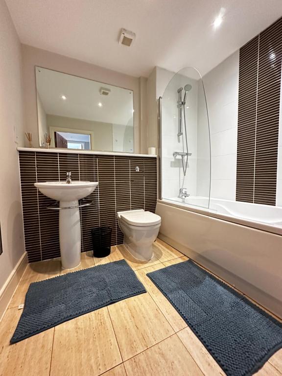 un bagno con lavandino, WC e vasca di Seaside APT with Harbour View a Swansea