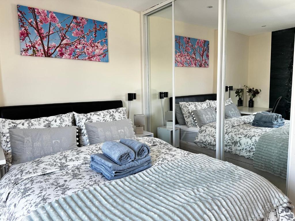 una camera con due letti e asciugamani sopra di Seaside APT with Harbour View a Swansea