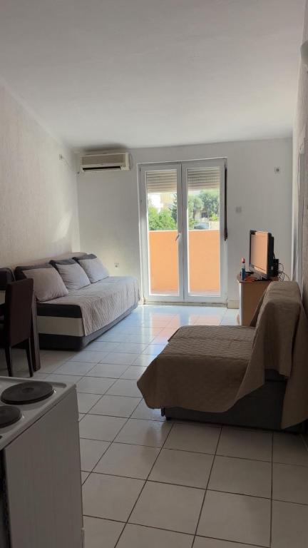 una camera d'albergo con due letti e una finestra di Apartman Drazen Rafailovici a Rafailovici