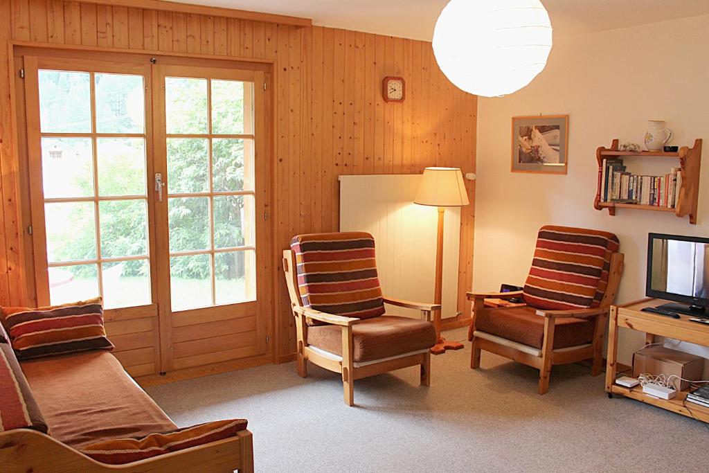 a living room with two chairs and a television at Bel Alp 2 Appartement avec jardin Evolene in Evolène