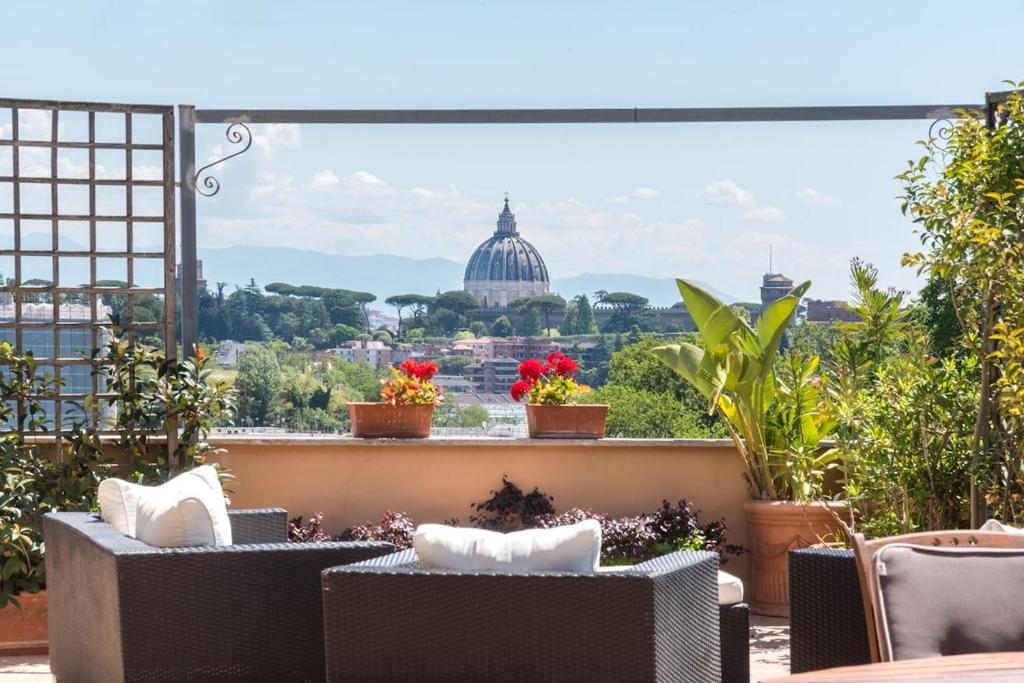 Un balcón con sillas y vista al Capitolio. en Vatican-Metro A Panoramic Penthouse with Jacuzzi, en Roma