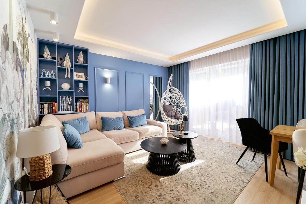 a living room with a couch and a table at LAGUNA Apartament Polanica Residence 14 SPA z tarasem in Polanica-Zdrój