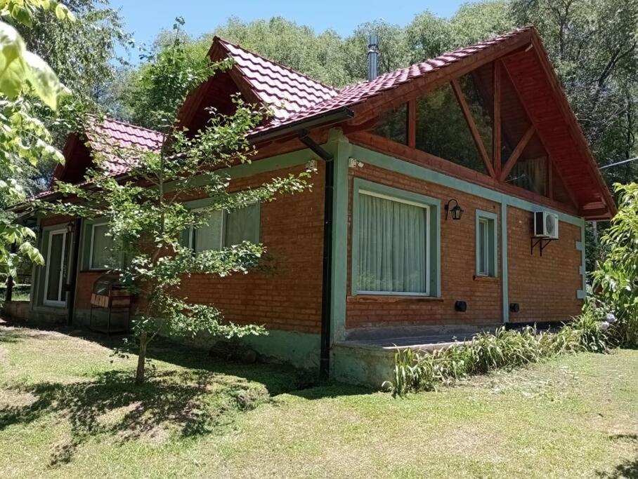 una pequeña casa de ladrillo con un árbol delante de ella en Chalet del arroyo, en La Porteña