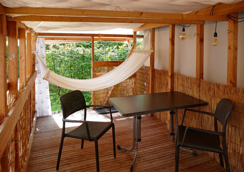 a table and chairs on a screened porch with a window at Refugio del Lago in Seekirchen am Wallersee